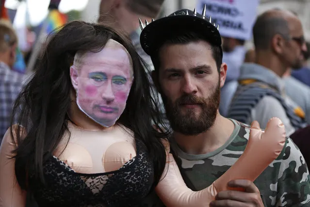 An activist holds a doll with a mask depicting Russian President Vladimir Putin as he participates at a protest against Russia's new law on gays, in central London, Saturday, August 10, 2013. Hundreds of protesters, called for the Winter 2014 Olympic Games to be taken away from Sochi, Russia, because of a new Russian law that bans “propaganda of nontraditional sexual relations” and imposes fines on those holding gay pride rallies. (Photo by Lefteris Pitarakis/AP Photo)