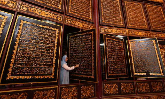 People visit the Bayt Al Quran Al Akbar Museum in Palembang, Indonesia on August 5, 2018. Parts of Holy Quran were beautifully carved on the 1,77 x 1,4 meters wide and 2,5 cm thick Tembesu wood at the 5-storey building. (Photo by Muhammad A .F./Anadolu Agency/Getty Images)