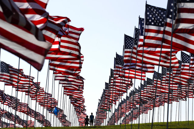 Bianca Burton, center left, and Erin Schultheis walk around the Pepperdine University's annual display of flags honoring the victims of the 9/11 terrorist attacks, Monday, September 10, 2018, in Malibu, Calif. Terrorists used hijacked planes to crash Sept. 11, 2001, into the World Trade Centers, the Pentagon and a field in Pennsylvania. Nearly 3,000 people were killed in the attacks. (Photo by Jae C. Hong/AP Photo)