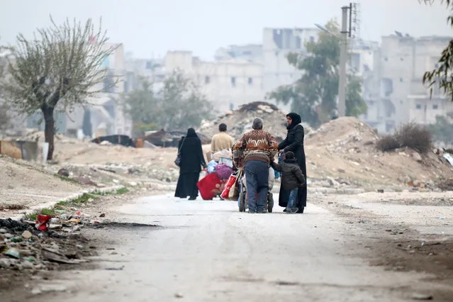 People carry their belongings as they flee the Kadi Askar area towards Bustan al-Qasr neighbourhood, in rebel-held besieged Kadi Askar area of Aleppo, Syria December 5, 2016. (Photo by Abdalrhman Ismail/Reuters)