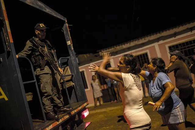 In this November 10, 2016 photo, women argue with a National Guard, saying they've detained the wrong men while cracking down on pirates in Punta de Araya, Sucre state, Venezuela. After villagers protested they knew their suspects to be honest fishermen, the soldiers let the three men go. (Photo by Rodrigo Abd/AP Photo)