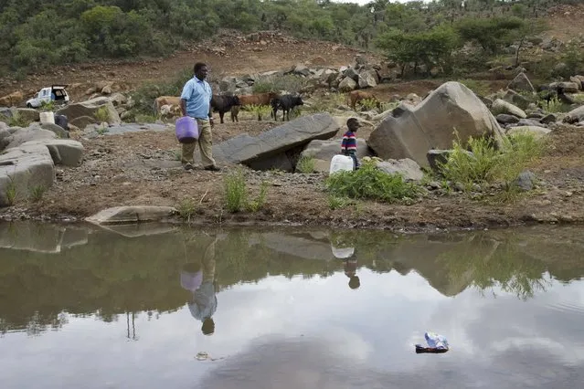 A man and his grandchildren collect water from the Nkuzana River as water to homes has been cut off due to drought near Pongola, northeast of Durban, January 20, 2016. (Photo by Rogan Ward/Reuters)