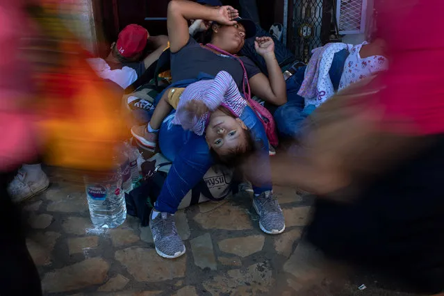 Shoppers pass by as Eleana Ramos, a two year old girl from Honduras, lies on her mother as they take rest with a caravan of thousands of migrants from Central America en route to the United States, in the Tapachula city center, Mexico October 22, 2018. (Photo by Adrees Latif/Reuters)