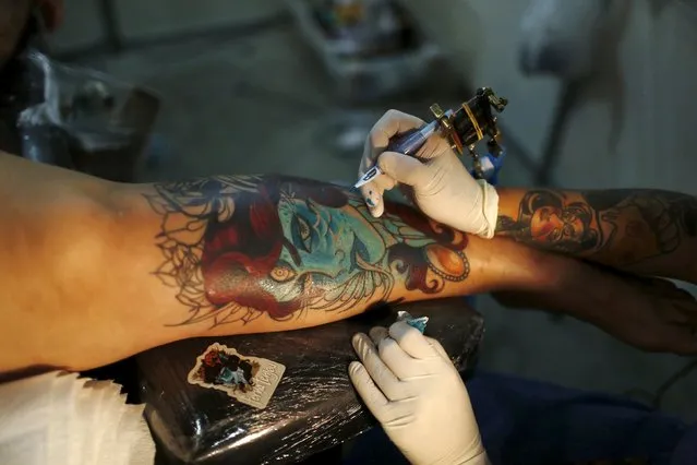 An artist works on a tattoo on the leg of a woman during the third International Tattoo Week Rio 2016 festival in Rio de Janeiro, Brazil, January 22, 2016. (Photo by Pilar Olivares/Reuters)