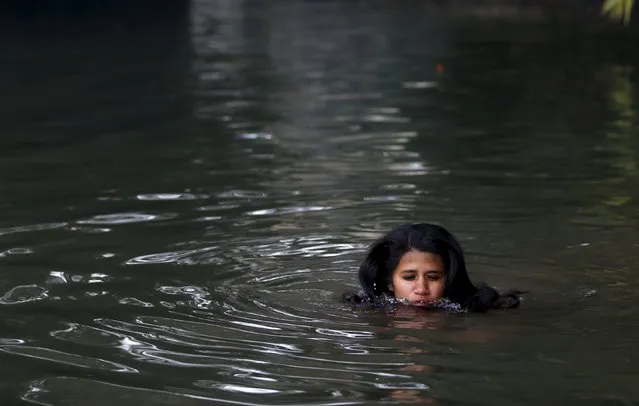 A devotee takes a holy bath in River Saali in Sankhu during the Swasthani Brata Katha festival in Kathmandu, Nepal, January 24, 2016. (Photo by Navesh Chitrakar/Reuters)