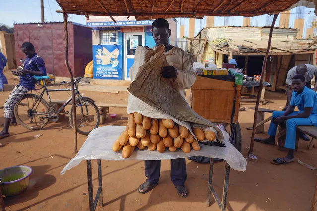 A man sells baguettes in Niamey, Niger, Friday, August 11, 2023. The ECOWAS bloc said it had directed a “standby force” to restore constitutional order in Niger after its deadline to reinstate ousted President Mohamed Bazoum expired. (Photo by Sam Mednick/AP Photo)
