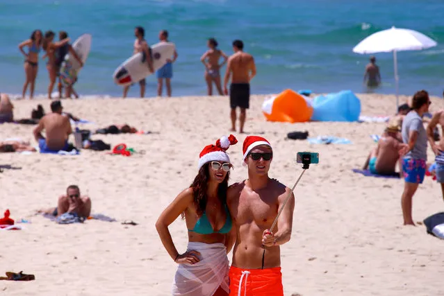 Tourists take a selfie as they wear Christmas hats and celebrate Christmas Day at Sydney's Bondi Beach in Australia, December 25, 2016. (Photo by David Gray/Reuters)