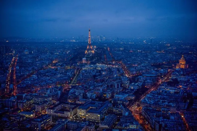 This general view taken from the rooftop of The Tour Montparnasse at twilight on January 8, 2018, shows The Eiffel Tower (C) and The Dome des Invalides (R) in Paris. (Photo by Christophe Simon/AFP Photo)