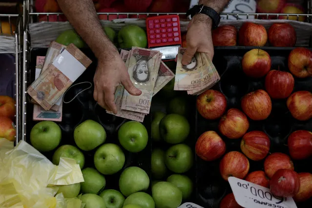 A cashier counts Venezuelan bolivar notes at a market in downtown Caracas, Venezuela, December 7, 2016. (Photo by Ueslei Marcelino/Reuters)