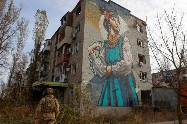 A Ukrainian serviceman walks next to a residential building heavily damaged by permanent Russian military strikes in the front line town of Avdiivka, amid Russia's attack on Ukraine, in Donetsk region, Ukraine on November 8, 2023. (Photo by Serhiy Nuzhnenko/Radio Free Europe/Radio Liberty)