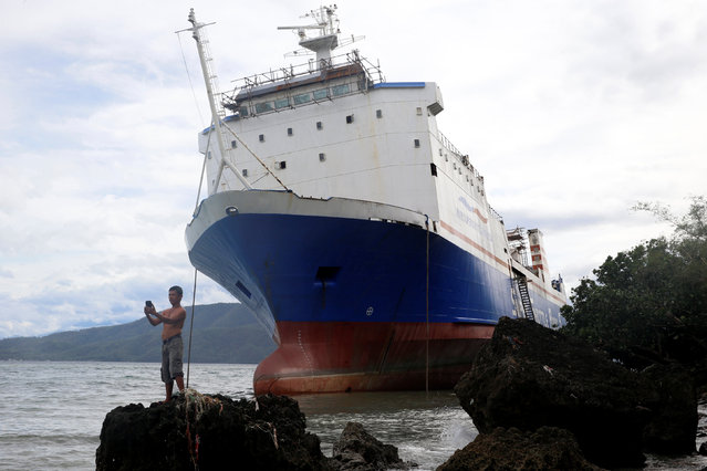 A resident takes a selfie in front of a passenger inter-island ferry Shuttle RoRo 5 that was swept ashore at the height of Typhoon Nock-Ten in Mabini, Batangas in the Philippines December 26, 2016. (Photo by Erik De Castro/Reuters)