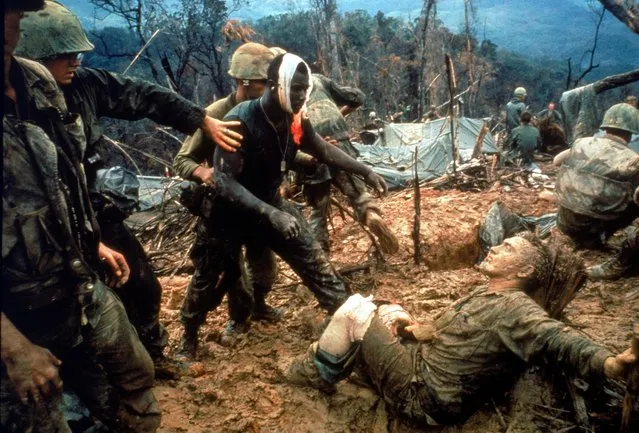 Wounded Marine Gunnery Sgt. Jeremiah Purdie (C) being led past stricken comrade after fierce firefight for control of Hill 484, S. of DMZ, S. Vietnam, 1966. (Photo by Larry Burrows/The LIFE Picture Collection/Getty Images)