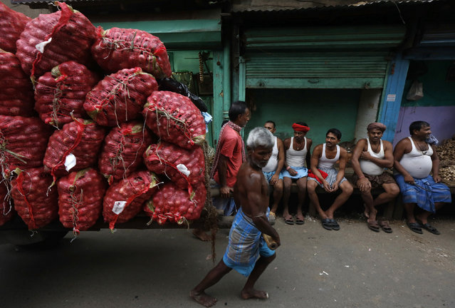 Labourers pull a handcart loaded with onion sacks at a wholesale market in Kolkata, India, February 26, 2016. (Photo by Rupak De Chowdhuri/Reuters)