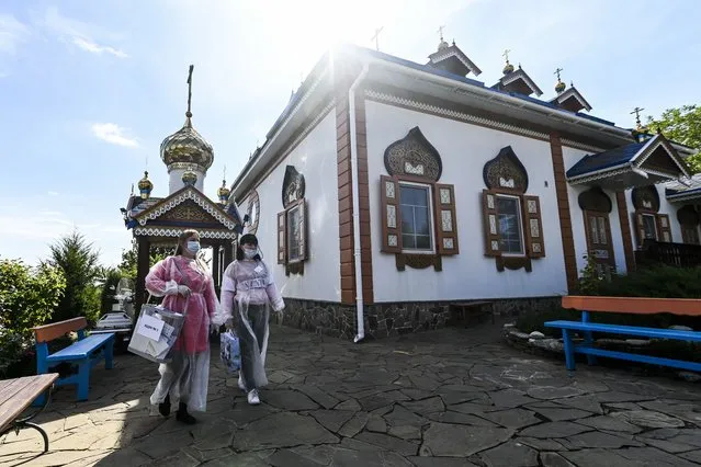 Members of an election commission walk to help an elderly person to vote at its house in Starozolotovsky village, 160 km (100 miles) north of Rostov-on-Don during the Parliamentary elections , Russia, Saturday, September 18, 2021. Sunday is the last of three days voting for a new parliament, but there seems to be no expectation that United Russia, the party devoted to President Vladimir Putin, will lose its dominance in the State DumaSeptember 27, 2020. (Photo by AP Photo/Stringer)