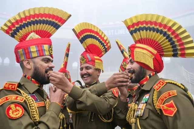 Indian Border Security Force (BSF) soldiers offer sweets to each other as part of the celebrations to mark country's Republic Day at the India-Pakistan Wagah border post, about 35km from Amritsar on January 26, 2024. (Photo by Narinder Nanu/AFP Photo)