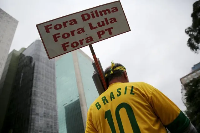 A demonstrator attends a protest against Brazil's President Dilma Rousseff, part of nationwide protests calling for her impeachment, in Sao Paulo, Brazil, March 13, 2016. The placard reads, “Out Dilma, Out Lula and Out PT (Workers' Party)”. (Photo by Nacho Doce/Reuters)