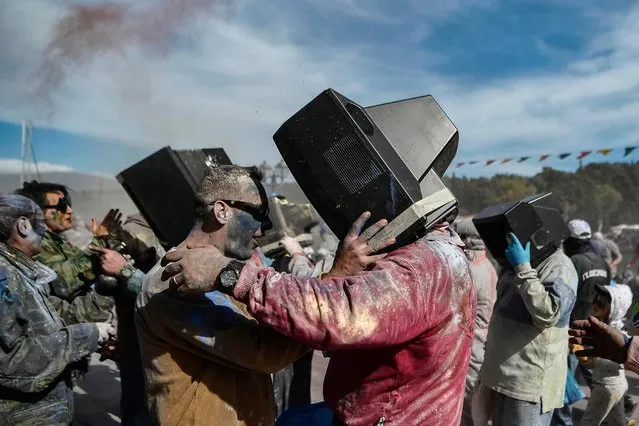 Revellers use old TVs as masks as they participate in a “flour war” during “Ash Monday” celebration, a traditional festivity marking the end of the carnival season and the start of the 40-day Lent period until the Orthodox Easter, in the port town of Galaxidi, Greece, on March 11, 2019. (Photo by Aris Messinis/AFP Photo)