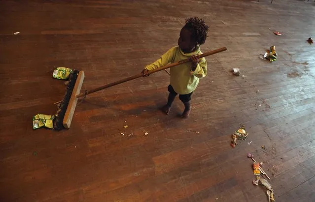 A child plays with a broom at a shelter for victims of immigrant attacks in Johannesburg, Wednesday, April 22, 2015. (Photo by Denis Farrell/AP Photo)