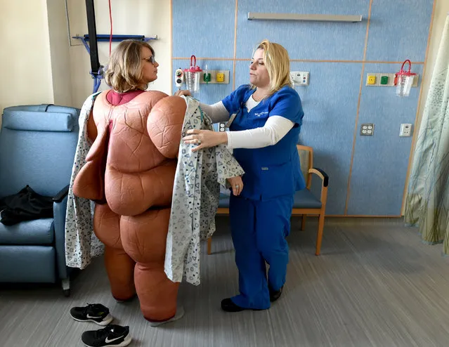 In this Friday, February 12, 2016, file photo, nurse Brittany Boebert, left, is assisted by nurse Bethany Mulone, a bariatric educator, in trying on a bariatric patient simulation suit used for training at the dedicated Bariatric Surgery Unit on the Saint Raphael campus of Yale-New Haven Hospital in New Haven, Conn. Bariatric surgery is becoming more common, driven by growing epidemics of obesity and diabetes, improved techniques and wider insurance coverage. Still, finances and fear deter many patients who are morbidly obese, meaning excess weight and related health problems likely will kill them prematurely. (Peter Hvizdak/New Haven Register via AP Photo)