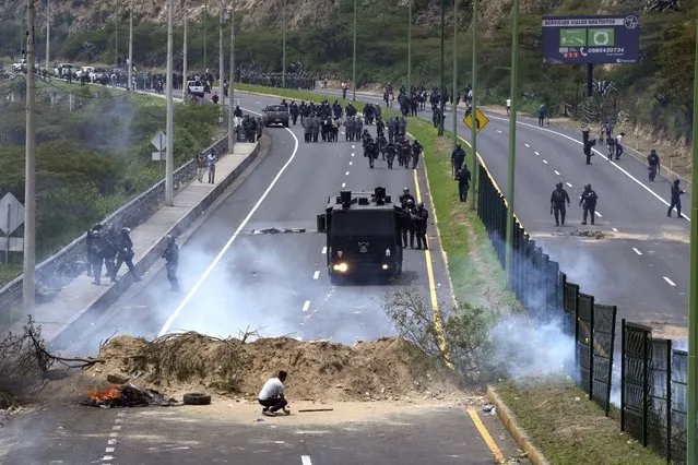 Police advance on people protesting the rise in gas prices and the policies of Ecuador's President Guillermo Lasso, on the second day of a general, nation-wide strike, in Quito, Ecuador, Wednesday, October 27, 2021. (Photo by Dolores Ochoa/AP Photo)