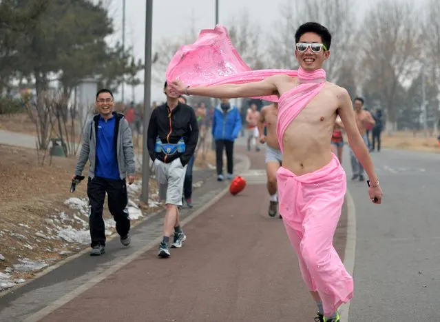 This picture taken on February 23, 2014 shows a participant (R) running in the annual 3.5 km Undie Run held in the Olympic Forest Park smog-covered Beijing. (Photo by AFP Photo/STR)