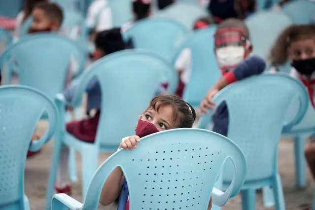 Children sit after the opening ceremony of the new school year for primary school students, in Havana, Cuba, November 15, 2021. (Photo by Alexandre Meneghini/Reuters)