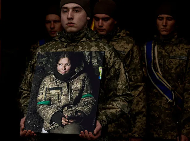 A Ukrainian serviceman carries a portrait of Diana Savita Wagner, a German combat medic, who joined Ukrainian Armed Forces as a volunteer and was killed by Russian troops in the country's East, during her funeral ceremony in Kyiv, Ukraine on February 14, 2024. (Photo by Valentyn Ogirenko/Reuters)