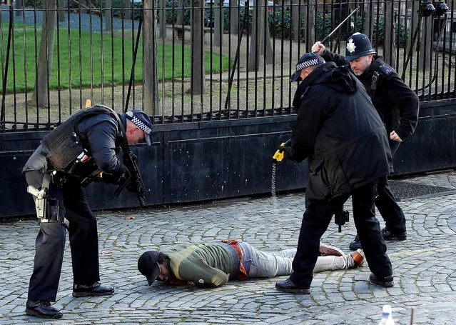 Armed police Taser a man inside the grounds of the Houses of Parliament on 11 December 2018. (Photo by Peter Nicholls/Reuters)