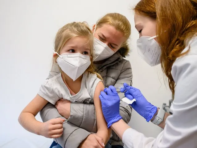 A young girl receives a dose of the Pfizer-BioNTech vaccine against Covid-19 developed for children between 5 and 11 years of age, at the Fejer County Szent Gyorgy Teaching Hospital in Szekesfehervar, Hungary, 15 December 2021, as the vaccination of children begins in the country. (Photo by Tamas Vasvari/EPA/EFE)