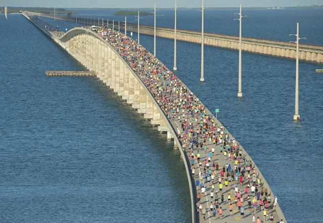 In this aerial photo provided by the Florida Keys News Bureau, a portion of the field of 1,500 runners climbs the “hump” of the Seven Mile Bridge in the Florida Keys, April 9, 2016, at the Seven Mile Bridge Run near Marathon, Fla. The race was initiated in 1982 to mark the completion of a federally funded program to build a new Seven Mile Bridge and 36 other spans for the Florida Keys Overseas Highway. (Photo by Andy Newman/Florida Keys News Bureau via AP Photo)