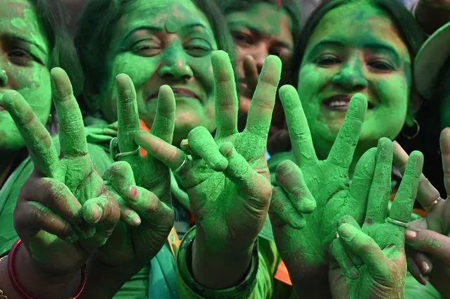 Supporters of the Trinamool Congress (TMC) celebrate the party's victory in the Kolkata Municipal Corporation (KMC) elections, near the residence of the India's West Bengal Chief Minister and TMC leader Mamata Banerjee, in Kolkata on December 21, 2021. (Photo by Dibyangshu Sarkar/AFP Photo)