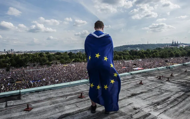 A man wrapped in an European flag oversees a rally demanding the resignation of Czech Prime Minister Andrej Babis on June 23, 2019 in Prague. Huge crowds flooded central Prague demanding Prime Minister Andrej Babis to step down over allegations of graft in a protest that organisers and local media claim drew around 250,000 people, which would make it the largest since the fall of communism in 1989. (Photo by Michal Cizek/AFP Photo)