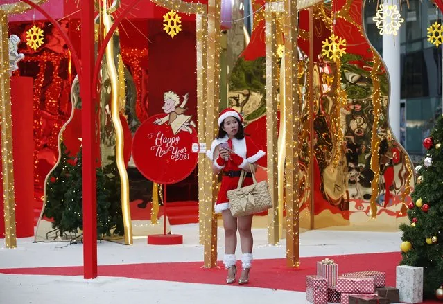 A Thai woman dressed in Santa costume stands next to an illuminated Christmas decoration to celebrate the upcoming festive season at a shopping mall in Bangkok, Thailand, 08 December 2020. The decorations are installed to attract Thais and foreigners to celebrate the Christmas and New Year holidays aimed to boost the tourism industry in the wake of the COVID-19 coronavirus pandemic. (Photo by Rungroj Yongrit/EPA/EFE)