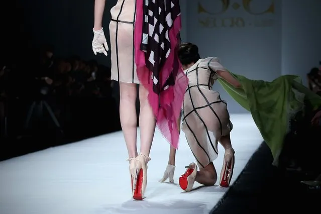 A model falls during the SECCRY Hu Sheguang Collection 2014 Show during Mercedes-Benz China Fashion Week, March 30, 2014, in Beijing. (Photo by Feng Li/Getty Images)