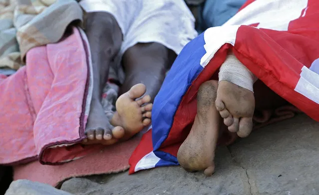 Migrants sleep on the rocky beach at the Franco-Italian border near Menton, southeastern France Wednesday, June 17, 2015. European Union nations failed to bridge differences Tuesday over an emergency plan to share the burden of the thousands of refugees crossing the Mediterranean Sea, while on the French-Italian border, police in riot gear forcibly removed dozens of migrants. (AP Photo/Lionel Cironneau)