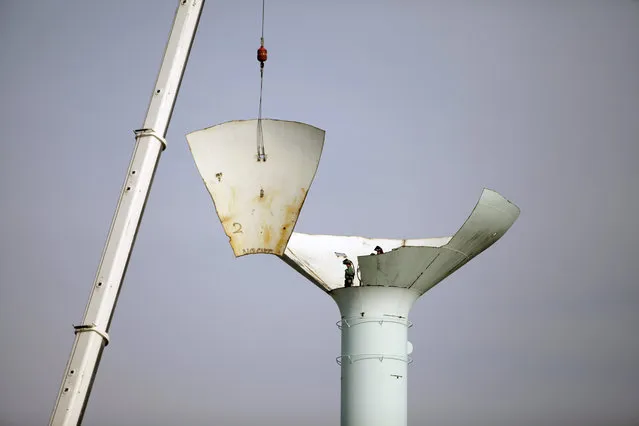 Workers disassemble a water tower, Tuesday, April 8, 2014, on Fort Meigs Road in Perrysburg, Ohio. Crews started taking down the top part of the water tower last month but ice delayed the project. (Photo by J. D. Pooley/AP Photo/Sentinel-Tribune)