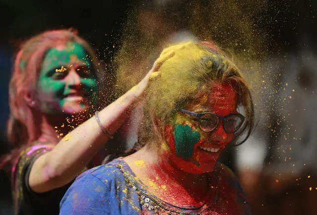 An Indian girl applies colored powder on a her friend as they celebrate Holi, the Hindu festival of colors, in Mumbai, India, Monday, March 13, 2017. (Photo by Rafiq Maqbool/AP Photo)