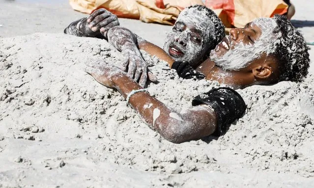 Somali revellers cover themselves with sand as they rest at the Lido beach in Mogadishu, Somalia on January 28, 2022. (Photo by Feisal Omar/Reuters)