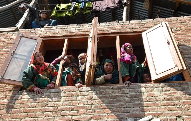 Kashmiri villagers watch the funeral procession of suspected rebel Shahbaz Shafi, also known as Rayees Kachroo, at Belov village in Pulwama, south of Srinagar, on March 27, 2017. Two suspected rebels were killed during an ambush by Indian government forces on March 26, 2017. Several rebel groups have spent decades fighting Indian soldiers deployed in the disputed territory, demanding independence or a merger with Pakistan which also claims the Himalayan region in its entirety. (Photo by Tauseef Mustafa/AFP Photo)
