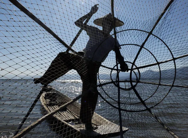 In this Friday, February 10, 2017, photo, an ethnic Inntha fisherman gathers his net on the Inle Lake, southern Shan State, Myanmar. (Photo by Thein Zaw/AP Photo)