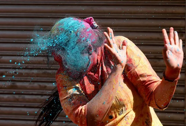 A woman reacts as coloured powder is thrown at her during Holi celebrations in Kolkata, India, March 18, 2022. (Photo by Rupak De Chowdhuri/Reuters)
