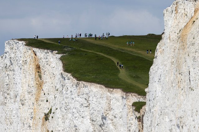 People walk on top of the cliff as they enjoy the weather at the Seven Sisters Cliffs, at Birling Gap in East Sussex county, Britain, on June 9, 2024. (Photo by Carlos Jasso/Reuters)