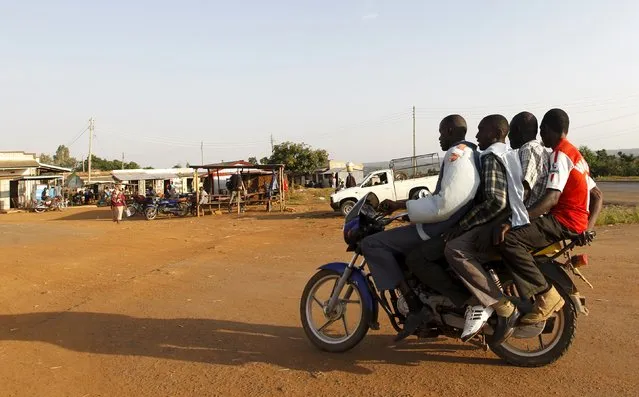 A motorbike taxi carries three passengers past the trading centre in the village of Kogelo, west of Kenya's capital Nairobi, July 15, 2015. (Photo by Thomas Mukoya/Reuters)