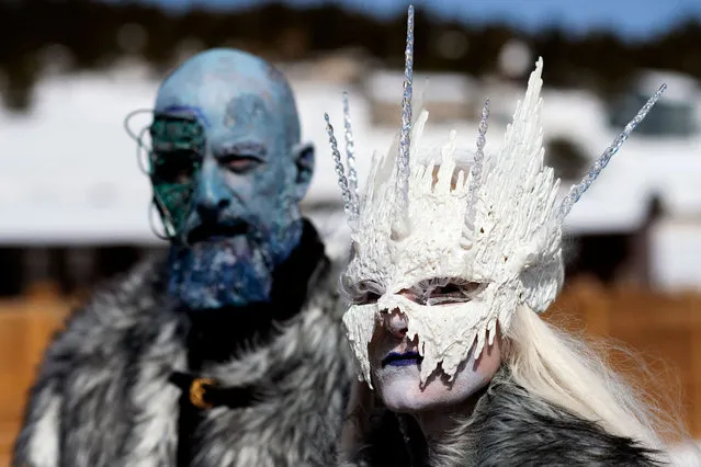 Karen Lichtfuss of Nederland, Colorado, dressed as the Ice Queen, stands in front of her husband Kurt during Frozen Dead Guy Days on March 19, 2022 in Nederland, Colorado. Frozen Dead Guy Days honors Bredo Morstol, who is frozen in a state of suspended animation and housed in a Tuff Shed in the hills above the town. Events such as the Parade of Hearses, coffin races, and a costumed polar plunge attract visitors to the two day festival each year. (Photo by Jason Connolly/AFP Photo)