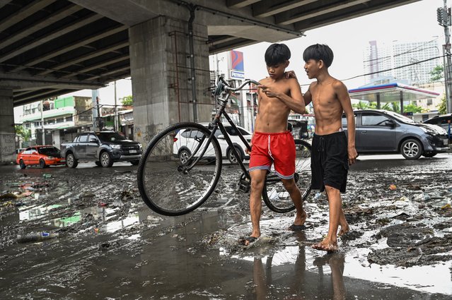 A boy carries his bicycle in the aftermath of Typhoon Gaemi in Manila on July 25, 2024. (Photo by Jam Sta Rosa/AFP Photo)