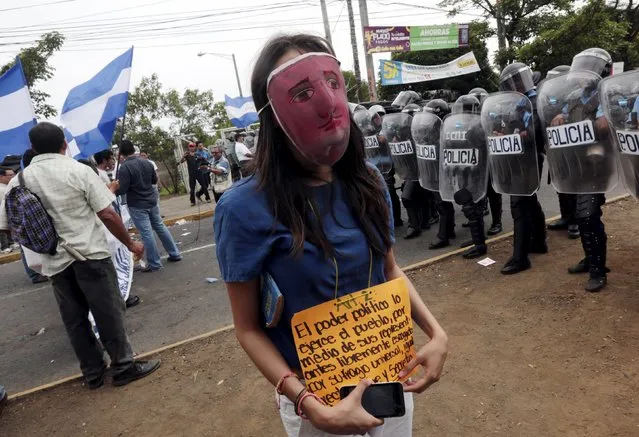 An opposition supporter takes part in a protest in front of the Supreme Electoral Council (CSE) building in Managua, Nicaragua July 29, 2015. The protesters said they were demonstrating to demand fairer elections in the country next year. The sign reads: “The political power is exercised by the people, through their representative freely chosen by universal, equal, direct and secret suffrage”. (Photo by Oswaldo Rivas/Reuters)