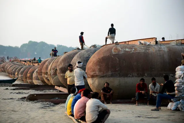Labourers rest during constructions of a temporary floating bridge over the river Ganges for the upcoming Magh Mela festival in Allahabad on December 16, 2019. (Photo by Sanjay Kanojia/AFP Photo)