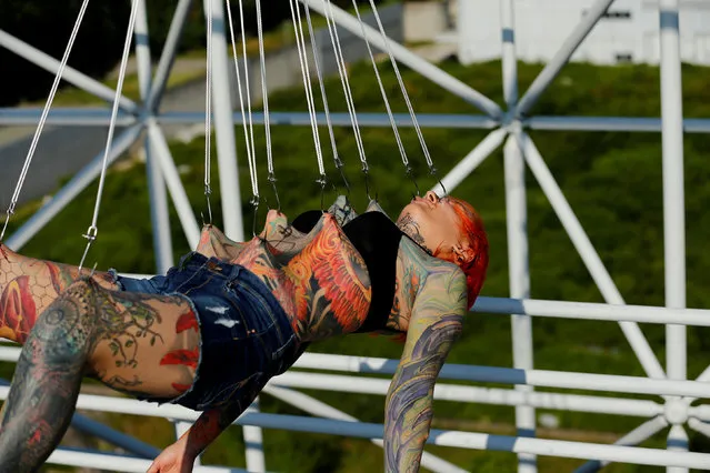 Kaitlin, 28, from the United States is suspended from hooks pierced through her skin by the professional body artist Dino Helvida in Zagreb, Croatia June 7, 2016. (Photo by Antonio Bronic/Reuters)