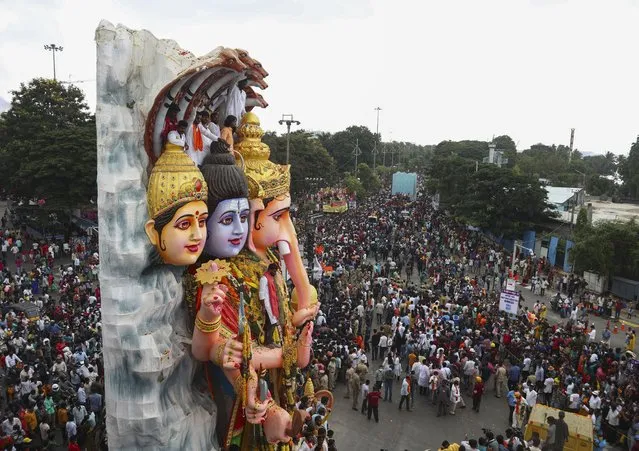 A giant idol of elephant-headed Hindu god Ganesha is taken in a procession for immersion in the Hussain Sagar Lake on the final day of Ganesh Chaturthi festival in Hyderabad, India, Sunday, September 19, 2021. (Photo by Mahesh Kumar A./AP Photo)