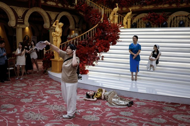 An assistant director gives instructions to actors on the set of a micro movie during a filming session at a banquet hall, in Zhengzhou, Henan province, China on July 16, 2024. (Photo by Tingshu Wang/Reuters)